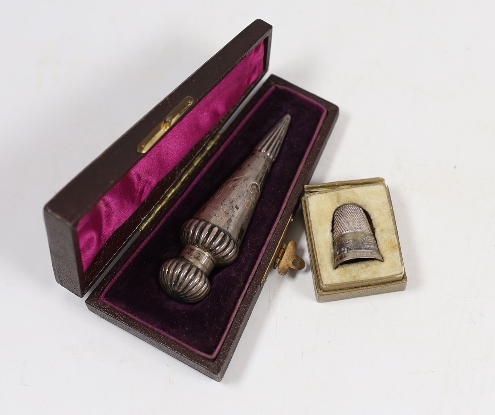 A cased late Victorian teardrop shaped silver scent bottle, Birmingham, 1885, 78mm and a cased silver thimble.